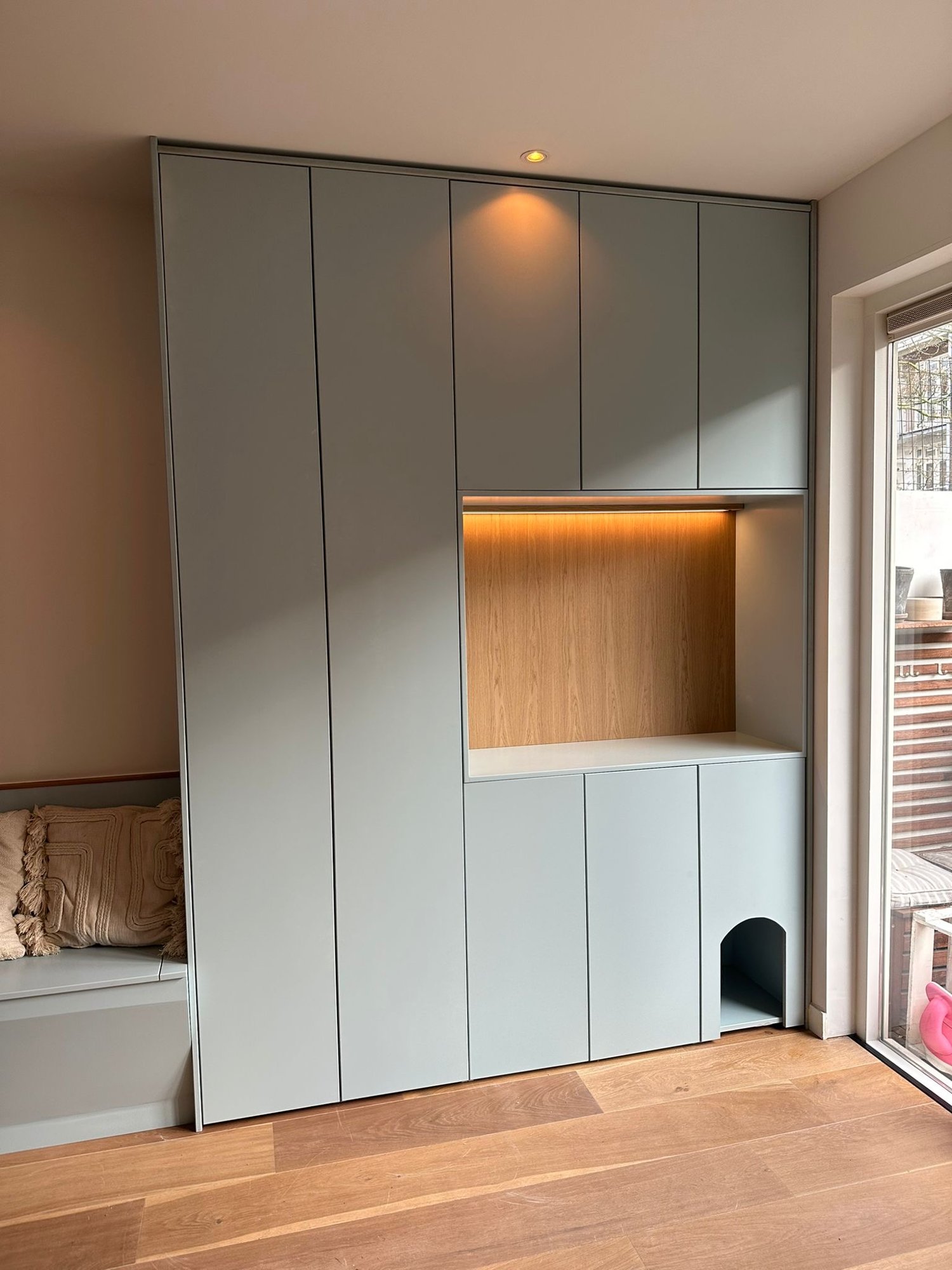Saliegroene kastenwand met zitbank