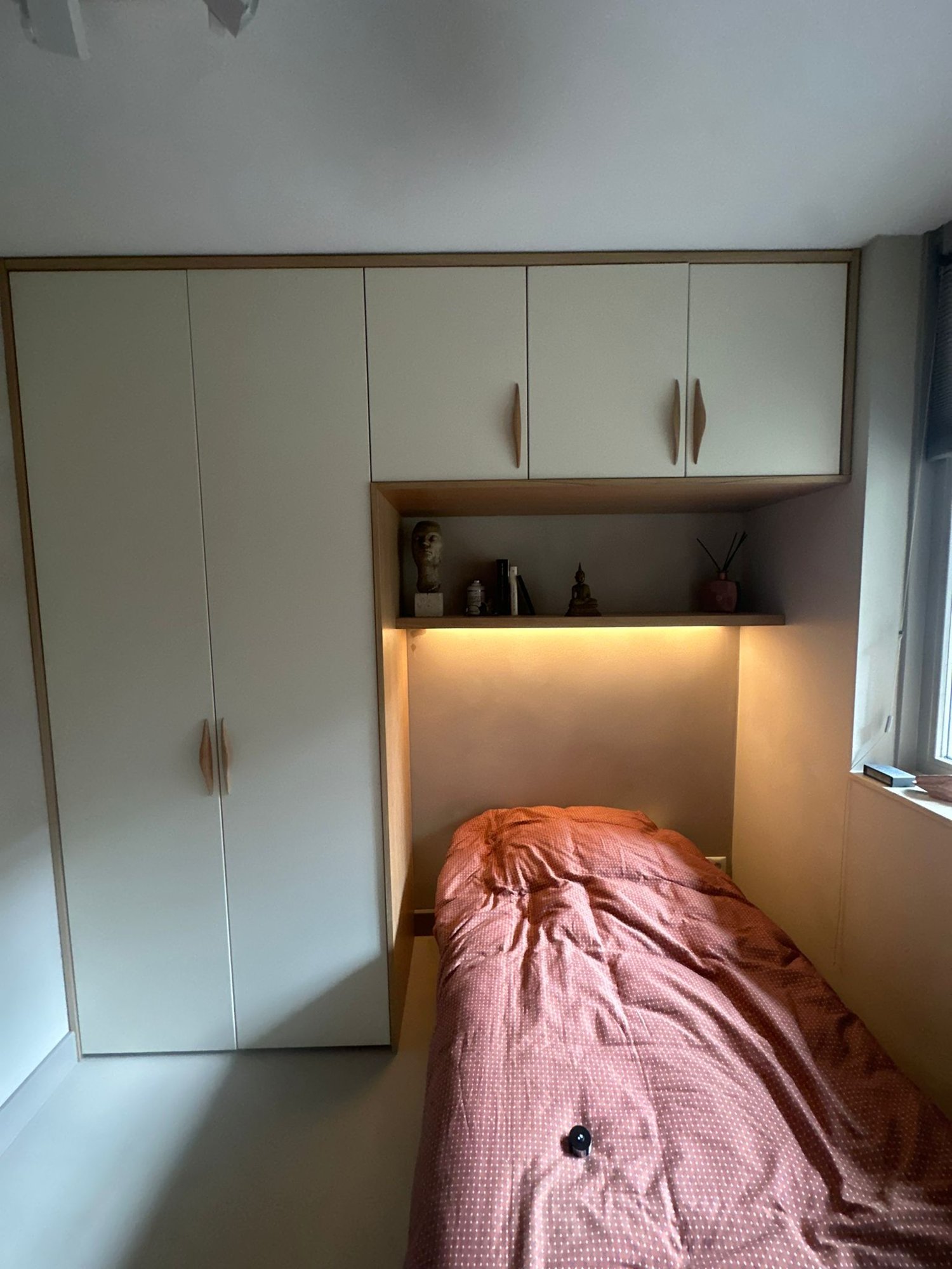 Bedwand met kasten en verlichte eiken nis