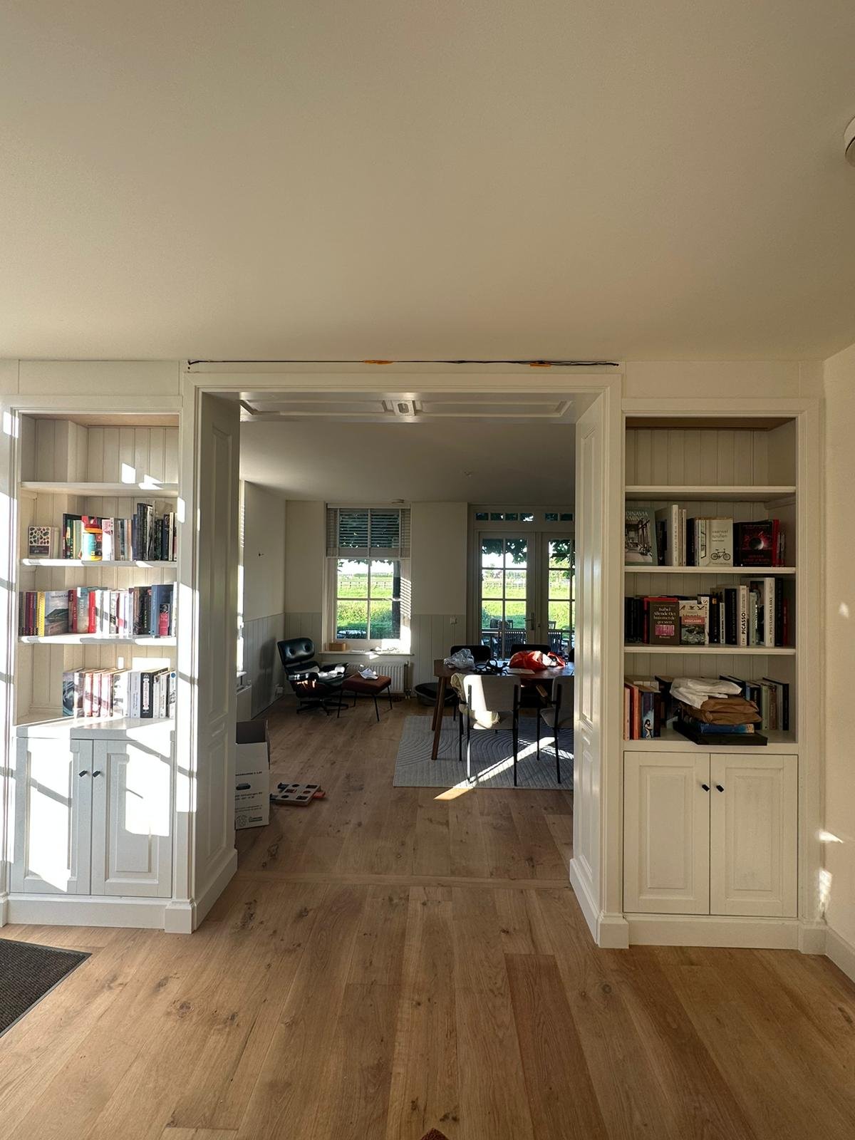 Witte boekenkasten rond een doorgang