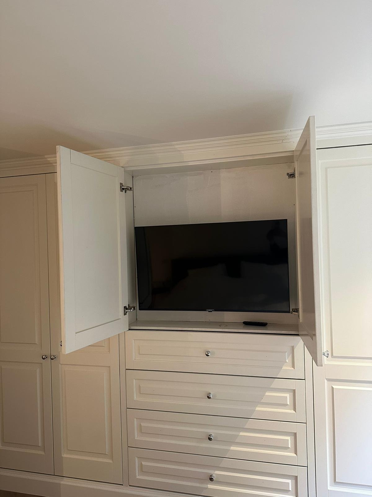 Kastenwand met verborgen tv achter deuren