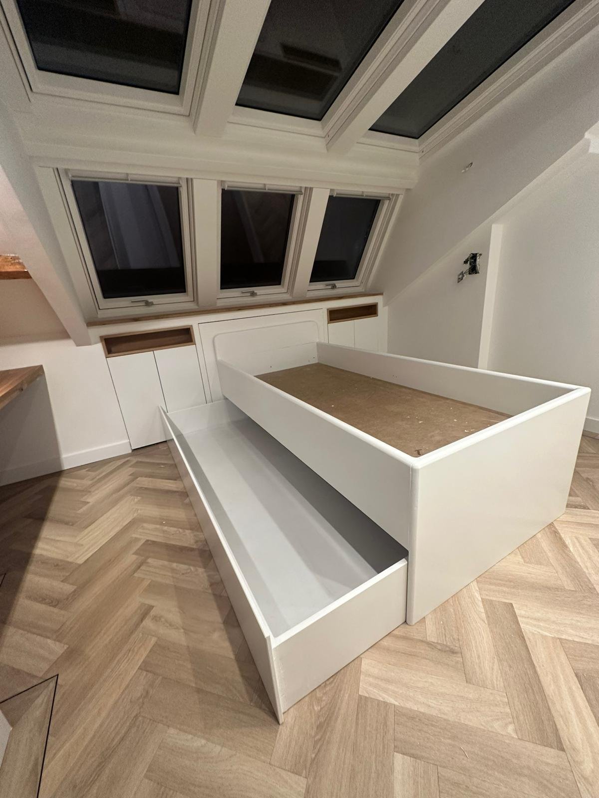 Bed met lades onder schuin dak